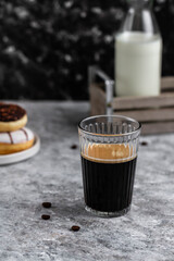 Black coffee in glass. Coffee and donuts