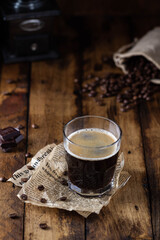 Black coffee in a glass with brown sugar crystals