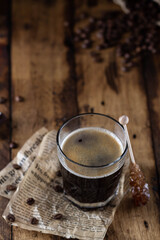 Black coffee in a glass with brown sugar crystals
