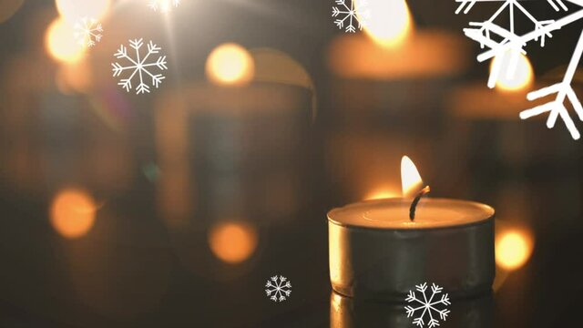 Animation of lit candle and falling multiple white snowflakes
