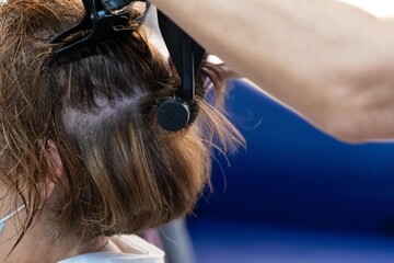 Lady who is having her hair cut in a hairdresser's