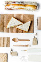 food delivery with paper bags and sandwich white background top view mock-up