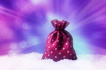 Obraz premium Christmas concept with Santa gift bag in snow over magic light