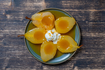 Baked pears in orange juice with ice cream, close up. Delicious dessert.