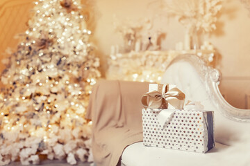 Fototapeta na wymiar Gift boxes with white ribbon on Christmas tree lights illumination background