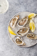 Fresh raw oysters on ice with lemon and glass of champagne