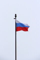 Fototapeta na wymiar Russian flag on a light sky background, white, blue and red tricolor