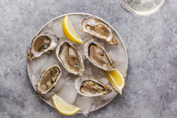 Fresh raw oysters on ice with lemon and glass of champagne