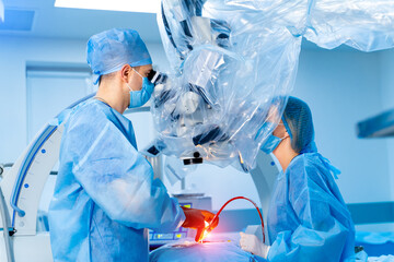 Seriuos doctors operate carefully using up to date neurosurgery equipment. Modern clinic surgical...