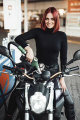 Fototapeta na wymiar It is important to keep your bike with enough fuel. Attractive young woman filling her motorcycle with fuel in station.