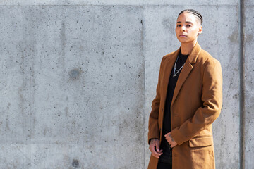 Young African American woman wearing long brown coat