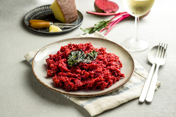 beetroot risotto with hard cheese, caramelized leaves,  dark black background