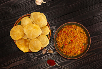 Suji/Sooji Halwa Puri or Shira Poori breakfast, served in a plate and bowl.