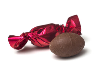 Closeup of chocolate candies in a red paper on white background