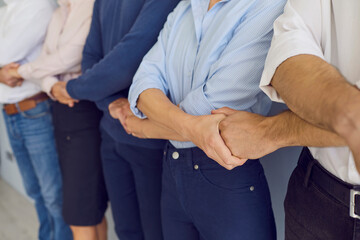 Obraz premium Hands of business people crossed holding standing on sides partners hands expressing teamwork