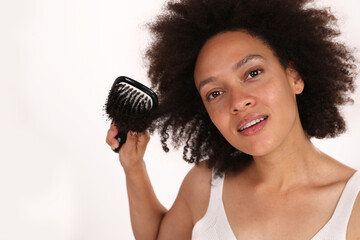 Happy Young Woman with afro hairstyle brushing her Hair isoletedon white. Carefree people,,...