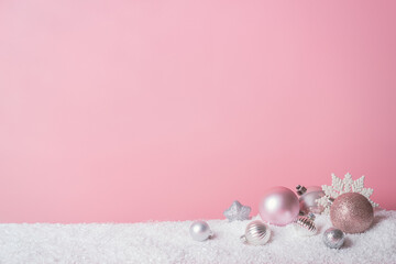 Christmas pink background with snow and balls. New Year's concept, idea, texture.