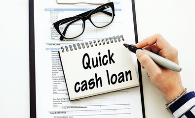 Quick cash loan - text written by business woman in her diary on office desk.