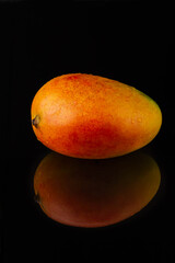 Fresh mango fruit on black background with reflection