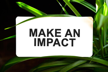 MAKE AN IMPACT text on white surrounded by green leaves