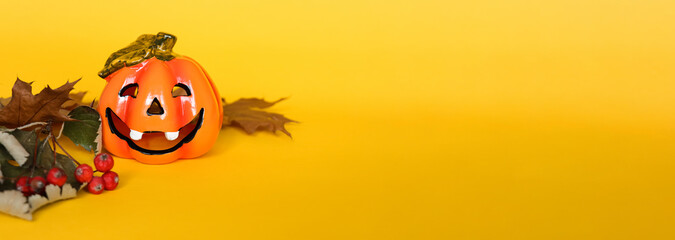 Yellow banner with halloween pumpkin and dry autumn leaves with place for text
