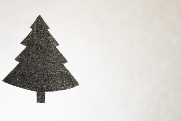 Silhouette of black christmas tree with glitter points on background like a snow. Copy space.
