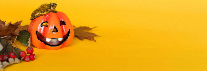 Yellow banner with halloween pumpkin and dry autumn leaves with place for text