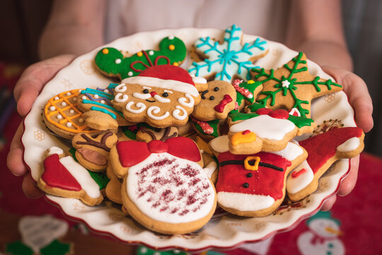 Hands Holding A Plate Of Christmas Gingerbread Cookies