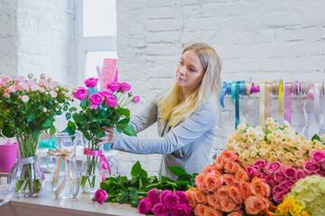 Professional floral artist, florist working with flowers at workshop, flower shop. Floristry, handmade and small business concept