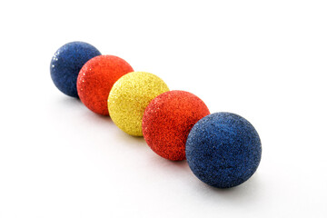 Five color Christmas baubles in row on white background. Selective focus.