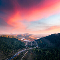 Aerial drone view over the autumn mountains with mountain road serpentine, river and forest. Landscape photography