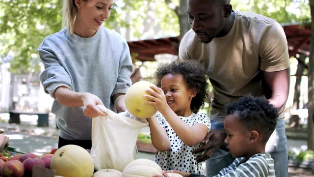 Multiracial family shopping in fruit market.