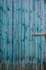 Vintage wooden background with faded turquoise peeling paint.