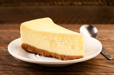 Cheesecake piece on a plate on a wooden background