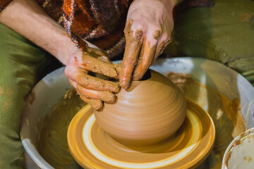 Professional male potter making pot on pottery wheel at workshop, studio. Handmade, art and...