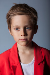 retrato de niño rubio y ojos azules con chaqueta roja 