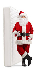 Full length portrait of santa claus leaning on a bed mattress
