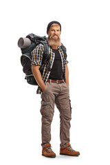 Full length portrait of a young bearded hiker with a backpack looking at camera