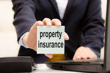 Obraz premium Property insurance protection concept. property insurance text is written on a blue sticker held by a business girl