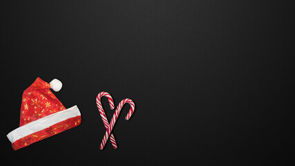 Red Christmas hat and candies on a black background.