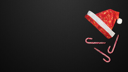 Red Christmas hat and candies on a black background.