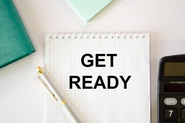 get ready text is written on a white sheet of notepad next to a calculator, notepad, pen