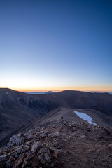 Fototapeta premium sunrise over mountain with lone hiker and snow