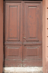 Red brown door with weathered frames, closed shutter with space for text, no person