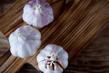 Garlic lies on a wooden chopping Board.