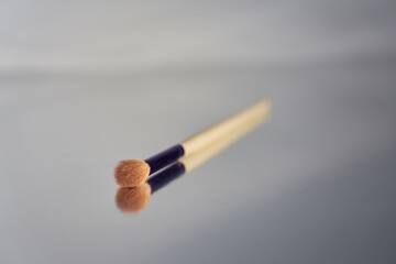makeup brush with mirror reflection on blurred background