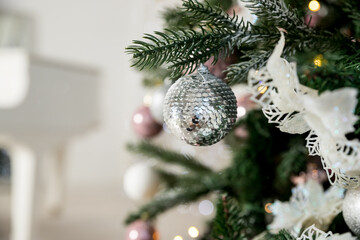 Christmas Decoration. Pink, silver and white Balls on Christmas tree branch. Holiday Card.Christmas toy ball hanging on branch of spruce. New year tree decorated with a garland.Stylish Christmas tree