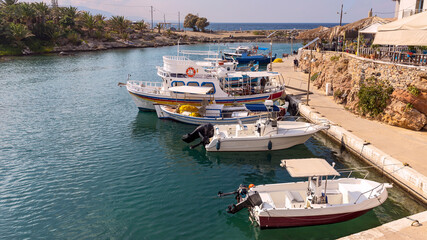 view of small sports and fishing boats in a quiet harbor at the Greek fishing village of Sissi