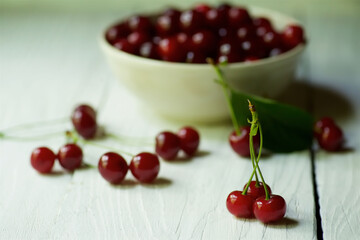 Fresh red berry cherry lies on the wooden surface of the table.