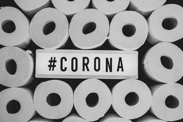  sign with the inscription #Corona can be found in the middle of many white toilet paper rolls